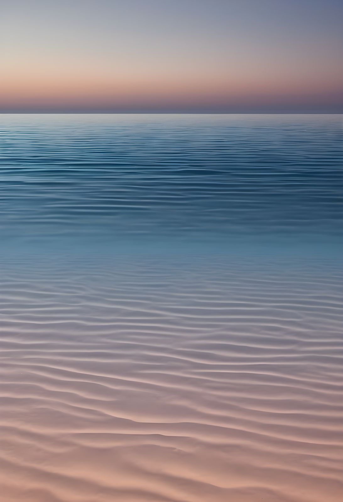 A thin horizon line over a gradient sea