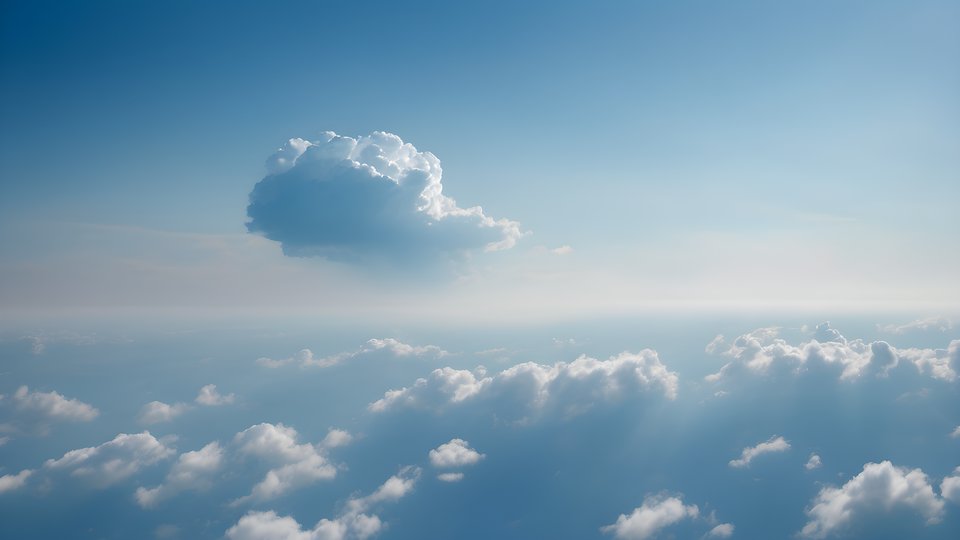 One small cloud drifting in a vast blue sky in soft morning light